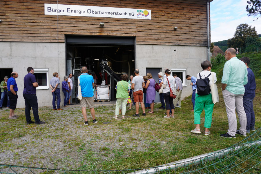 Teilnehmende der grenzüberschreitenden Exkursion vor dem Heizhausgebäude des Nahwärmenetzes im deutschen Oberharmersbach.