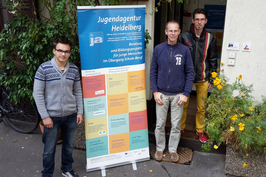 In der Jugendagentur Heidelberg eG: Schulpraktikant William Schäfer, Genossenschafts-Vorstandsmitglied Gerd Schaufelberger und ein junger Mann, der von der Jugendagentur unterstützt wird.