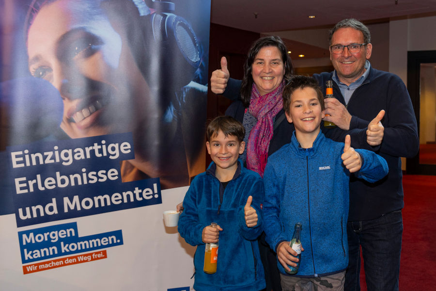 Familie beim Musical Tarzan vor Infowand der Volksbanken Raiffeisenbanken