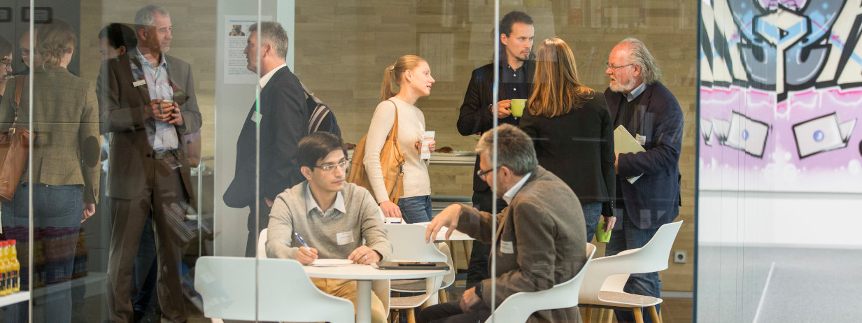Menschen unterhalten sich und diskutieren auf offener Bürofläche in modernem Ambiente