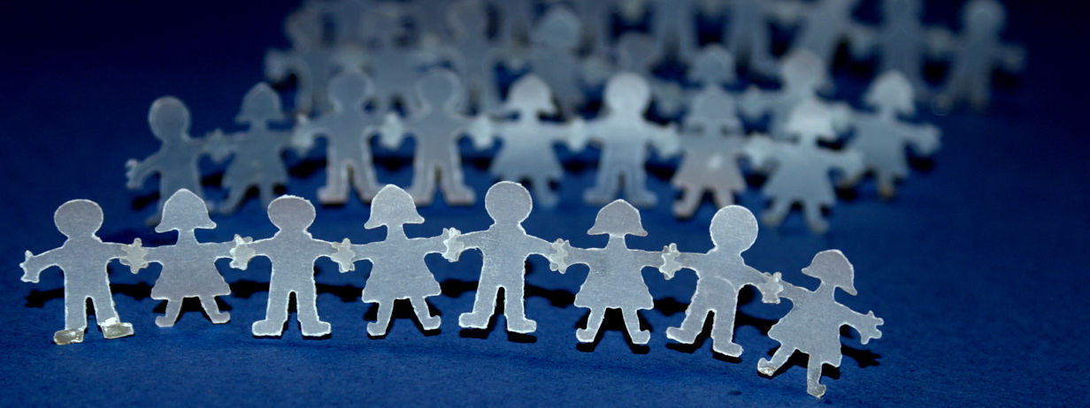Menschenkette aus Papier vor dunkelblauem Hintergrund