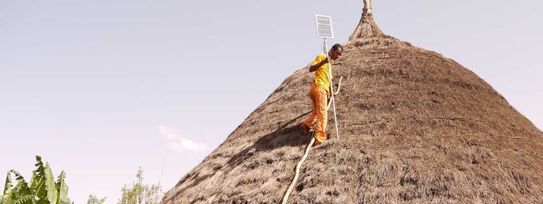 Eine Hütte in Äthiopien bekommt eine Solaranlage aufs Dach installiert.