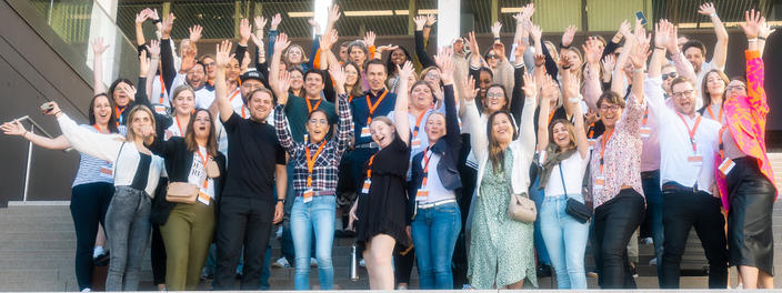 Gruppenfoto mit begeistert winkenden Menschen 