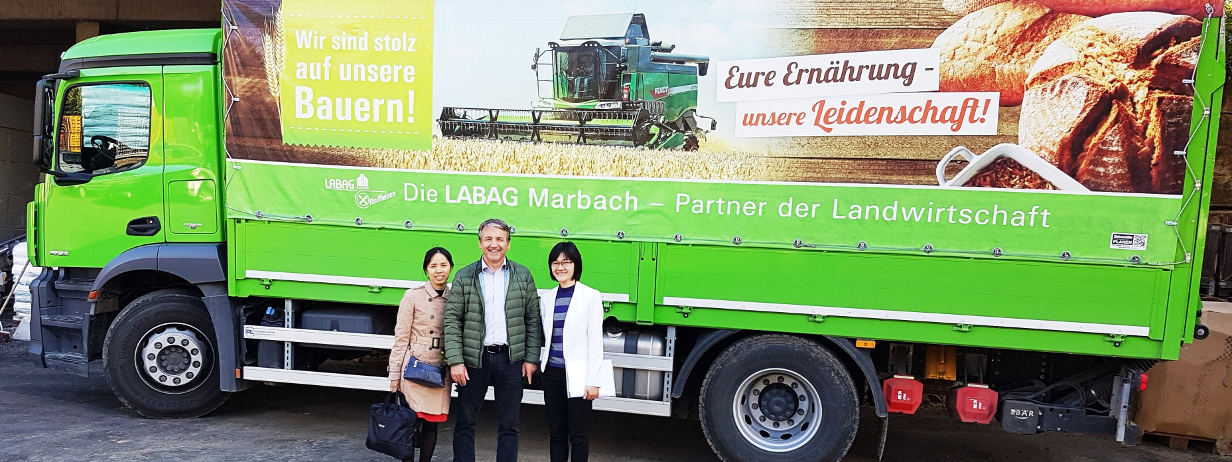 Zwei Besucherinnen aus Vietnam vor einem Lastwagen der Labag eG, Marbach