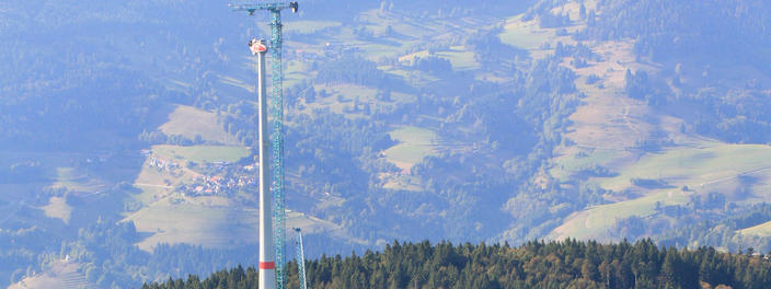 Aufbau einer Windkraftanlage vor blauem Himmel