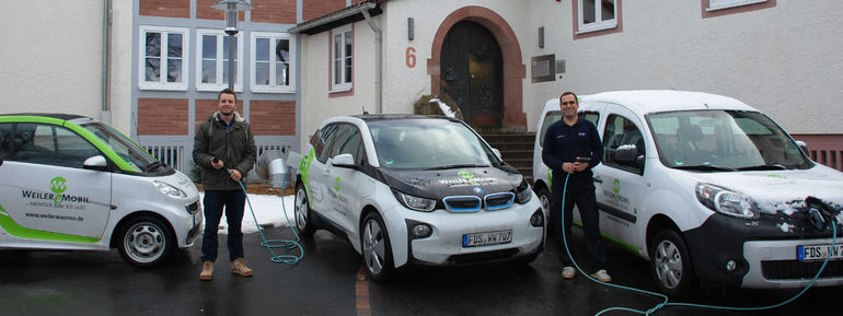 Fabian Strojek (links) vom Anbieter Weilere mobil und Elektroauto-Nutzer Bernd Moser vom Deutschen Roten Kreuz.