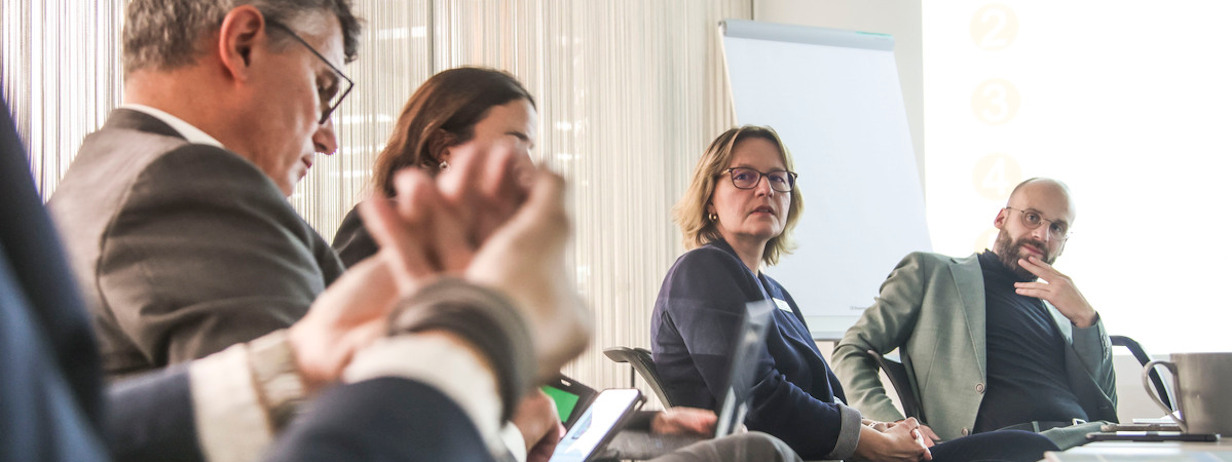 Entspannte Diskussion zwischen mehreren sitzenden Menschen im Business-Look